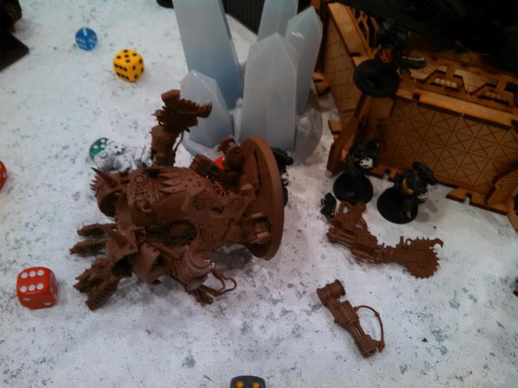 An Ork Deff Dread and other miniatures on the battlefield